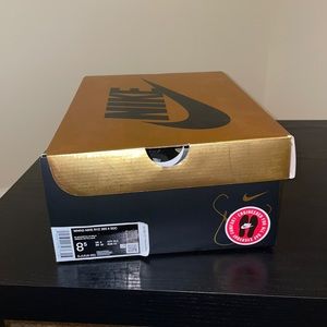 Black Metallic Gold Nike logo. Material is a mix of suede, leather and fabric.